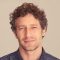 man with curly hair looking at the camera